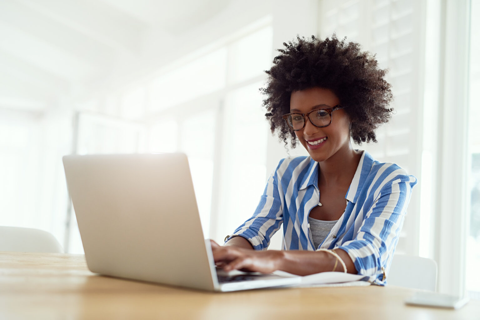 Self employed and totally loving it. Cropped shot of a young woman working on her laptop at home.